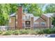Tan exterior with a brick chimney, black fence, and green trees in the background at 2120 River Heights Se Walk, Marietta, GA 30067