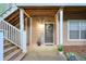 Inviting condo entrance featuring a welcome sign, potted flowers, and covered porch and staircase at 2120 River Heights Se Walk, Marietta, GA 30067