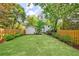 Large, grassy backyard with a white storage building and a wooden fence at 2840 Alpine Rd, Atlanta, GA 30305