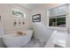 Bathroom featuring a standalone soaking tub, window, and decorative patterned floor tiles at 2840 Alpine Rd, Atlanta, GA 30305