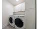 Well-equipped laundry room featuring modern washer and dryer, white cabinets, and stylish tile flooring at 2840 Alpine Rd, Atlanta, GA 30305