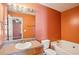 Bathroom with vanity, framed mirror, tub, and toilet. Bedroom visible through doorway at 5679 Windfall Ln, Lithonia, GA 30058