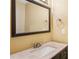 Bathroom vanity features a framed mirror, neutral countertop, and decorative light fixture at 5679 Windfall Ln, Lithonia, GA 30058