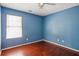 Bedroom features wood floors and blue walls with a window to provide natural light at 5679 Windfall Ln, Lithonia, GA 30058