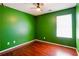 Bedroom features wood floors and green walls with a window to provide natural light at 5679 Windfall Ln, Lithonia, GA 30058