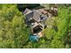 Aerial view of a luxurious home featuring a pool, patio, and mature landscaping at 105 Kingston Mnr, Atlanta, GA 30342