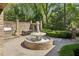 Landscaped backyard featuring a stone fountain with a statue and an outdoor dining area at 105 Kingston Mnr, Atlanta, GA 30342