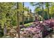 Lovely stone home with beautifully landscaped grounds, flowering bushes, and mature trees at 105 Kingston Mnr, Atlanta, GA 30342