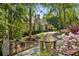 Charming stone home with lush landscaping and a private driveway nestled among mature trees at 105 Kingston Mnr, Atlanta, GA 30342