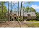 Beautiful home featuring a blend of brick and stone exterior, accented by mature trees and a manicured lawn at 105 Kingston Mnr, Atlanta, GA 30342