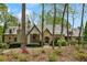 Stunning stone and brick home with a uniquely designed roof, complemented by natural landscaping at 105 Kingston Mnr, Atlanta, GA 30342