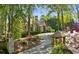 Stately stone home with lush landscaping, mature trees, and a winding driveway at 105 Kingston Mnr, Atlanta, GA 30342