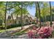 Charming stone home with blooming flowers, mature trees, and a well-maintained lawn at 105 Kingston Mnr, Atlanta, GA 30342