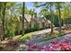 Charming stone home with blooming flowers, mature trees, and a well-maintained lawn at 105 Kingston Mnr, Atlanta, GA 30342