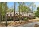 Elegant stone home with multiple dormers, mature trees, and a well-manicured lawn at 105 Kingston Mnr, Atlanta, GA 30342