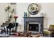 The living room fireplace is accented by a black grand piano, vase of red roses and large mirror at 105 Kingston Mnr, Atlanta, GA 30342