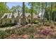 Charming stone home with a shake roof, chimney, beautiful landscaping, and mature trees at 105 Kingston Mnr, Atlanta, GA 30342
