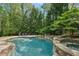 Beautiful stone pool with hot tub and slide surrounded by mature trees at 105 Kingston Mnr, Atlanta, GA 30342