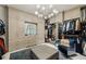 Spacious walk-in closet featuring ample storage with custom cabinetry, a center ottoman, and stylish lighting at 105 Kingston Mnr, Atlanta, GA 30342