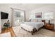 This is a cozy bedroom with a large window, a fur bench, hardwood floors, and a TV at 27 Spence Ne Ave, Atlanta, GA 30317