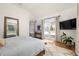 Bright bedroom features hardwood floors, a large mirror, patio doors and a TV on the wall at 27 Spence Ne Ave, Atlanta, GA 30317