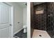 Bathroom featuring black hexagon tile floors, a toilet, and a shower with accent tile at 5000 Northland Sw Rd, Mableton, GA 30126