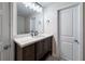 Bathroom featuring a wood vanity, dark hardware, quartz countertop, and modern vanity lighting at 5000 Northland Sw Rd, Mableton, GA 30126