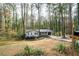 Exterior view of a single story home and driveway nestled among mature trees in a quiet neighborhood at 5000 Northland Sw Rd, Mableton, GA 30126