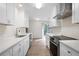 Bright kitchen featuring white cabinets, stainless steel appliances, and a view to the exterior at 5000 Northland Sw Rd, Mableton, GA 30126