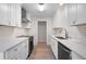 Modern kitchen with white cabinets, stainless steel appliances, quartz countertops, and wood-look floors at 5000 Northland Sw Rd, Mableton, GA 30126