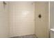 This is a walk in shower with vertically stacked tile and a matte finish grate drain at 5000 Northland Sw Rd, Mableton, GA 30126