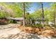 Scenic home nestled among mature trees, showcasing its charming facade and long driveway at 175 Flat Creek Ct, Fayetteville, GA 30214