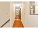Long hallway showcases hardwood flooring and neutral walls leading to bedrooms and living spaces at 175 Flat Creek Ct, Fayetteville, GA 30214
