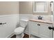 Well-lit half bathroom with vanity and white wainscoting at 2238 Well Springs Dr, Buford, GA 30519