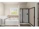 Bathroom featuring a soaking tub with tile backsplash, a shower with a black frame, and white cabinets at 2238 Well Springs Dr, Buford, GA 30519