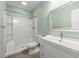 Bright bathroom featuring a shower-tub combo, modern vanity, and mint green walls at 2238 Well Springs Dr, Buford, GA 30519