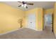 Cozy yellow bedroom features tree wall decor and ceiling fan at 2238 Well Springs Dr, Buford, GA 30519