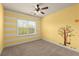 Bedroom features sunny yellow walls, striped accent wall, and a whimsical tree decal at 2238 Well Springs Dr, Buford, GA 30519