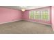 Spacious pink bedroom with three windows giving great light and neutral carpet at 2238 Well Springs Dr, Buford, GA 30519