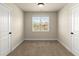 Neutral bedroom with a window offering plenty of natural light between two white doors at 2238 Well Springs Dr, Buford, GA 30519