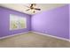 Empty purple bedroom with a window offering plenty of natural light and neutral carpet at 2238 Well Springs Dr, Buford, GA 30519