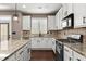 Modern kitchen featuring granite counters, stainless appliances, and white cabinets with backyard access at 2238 Well Springs Dr, Buford, GA 30519