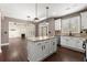 Open layout kitchen with granite island, stainless appliances, view to the fireplace and backyard access at 2238 Well Springs Dr, Buford, GA 30519