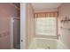A bathroom with a tub, shower, and window at 2261 Byron Sw Ct, Marietta, GA 30064