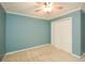Bedroom featuring carpet, neutral walls, a ceiling fan, white trim and bi-fold closet doors at 2261 Byron Sw Ct, Marietta, GA 30064