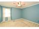 Bedroom with neutral carpet, blue walls, ceiling fan and a window with sheer curtains at 2261 Byron Sw Ct, Marietta, GA 30064