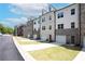 View of modern townhomes with brick and siding exteriors, driveways and lawns at 4956 Villager Ln, Stone Mountain, GA 30083
