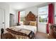 Light-filled bedroom with a wooden bed frame and views of the outdoors from the large windows at 558 Bismark Ne Rd, Atlanta, GA 30324