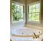 Bathroom featuring a large soaking tub and multiple windows at 180 Shyrewood Dr, Lawrenceville, GA 30043