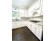 Well lit kitchen featuring white cabinets, granite countertops, and hardwood floors at 180 Shyrewood Dr, Lawrenceville, GA 30043